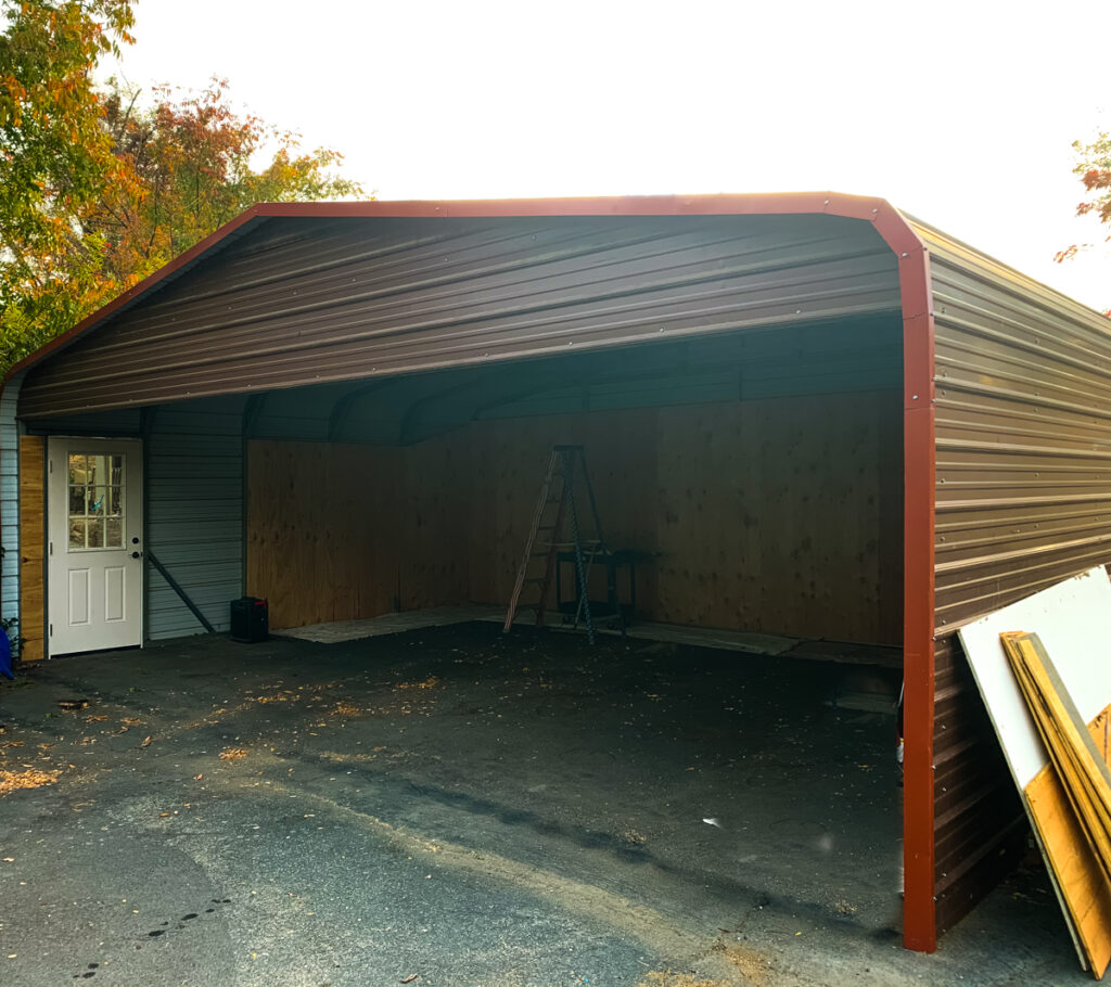 The photo shows the front of the carport with the interior walls finished in plywood/