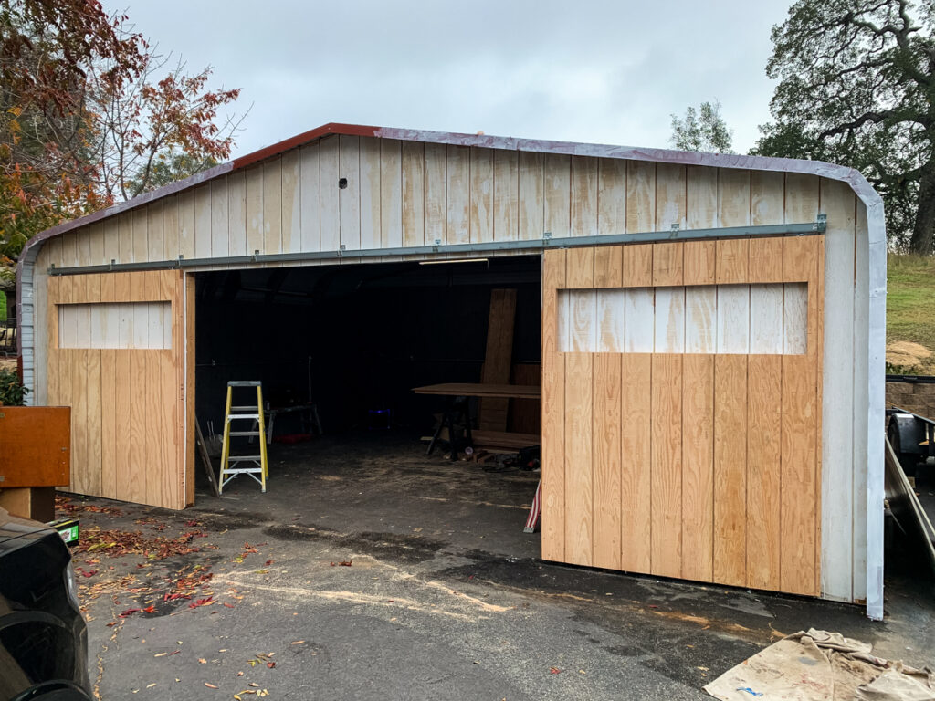 The carport barn is nearing completion, the front is sided and primer painted, the barn doors are hung.