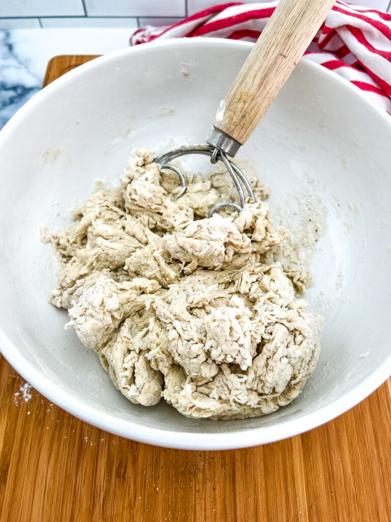 The photo shows dough at a dry and shaggy stage of mixture. 